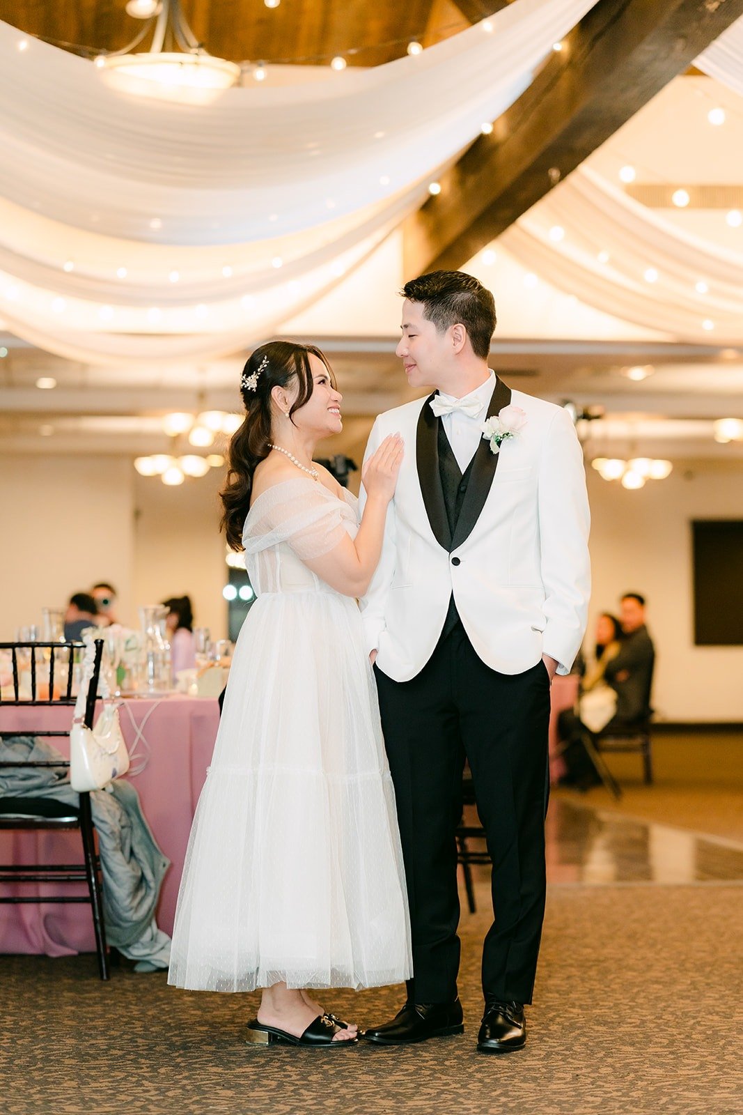 Ivy and Chungman standing on the dance floor under the draped ceiling