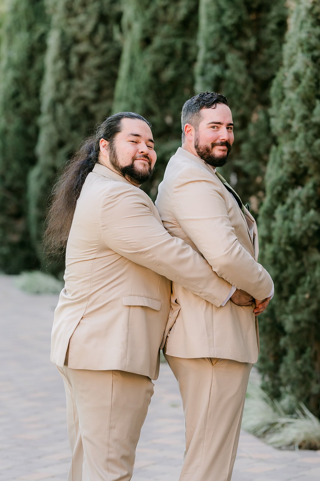 Cody and a groomsman posing in tan suits.