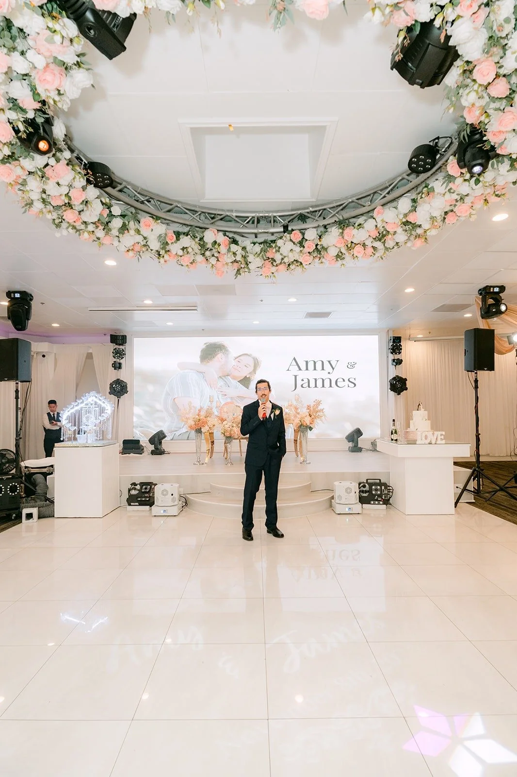 The host welcoming guests under the floral chandelier at Diamond Seafood Palace