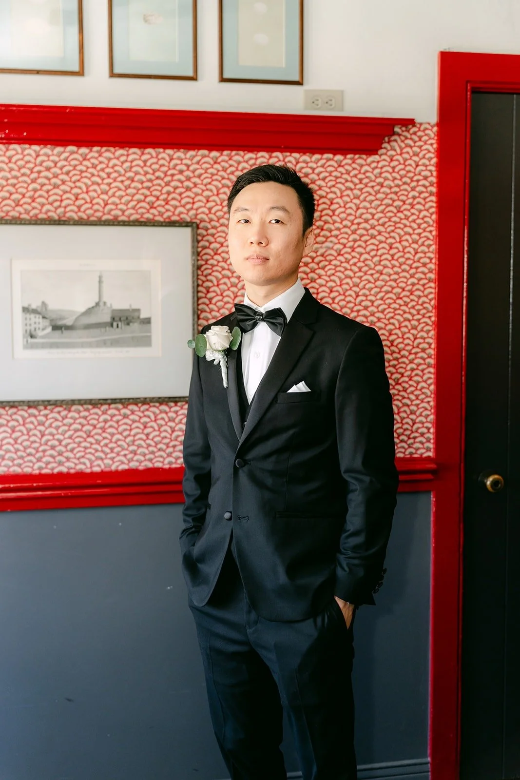 Jason standing against the red patterned wall at Five Crowns
