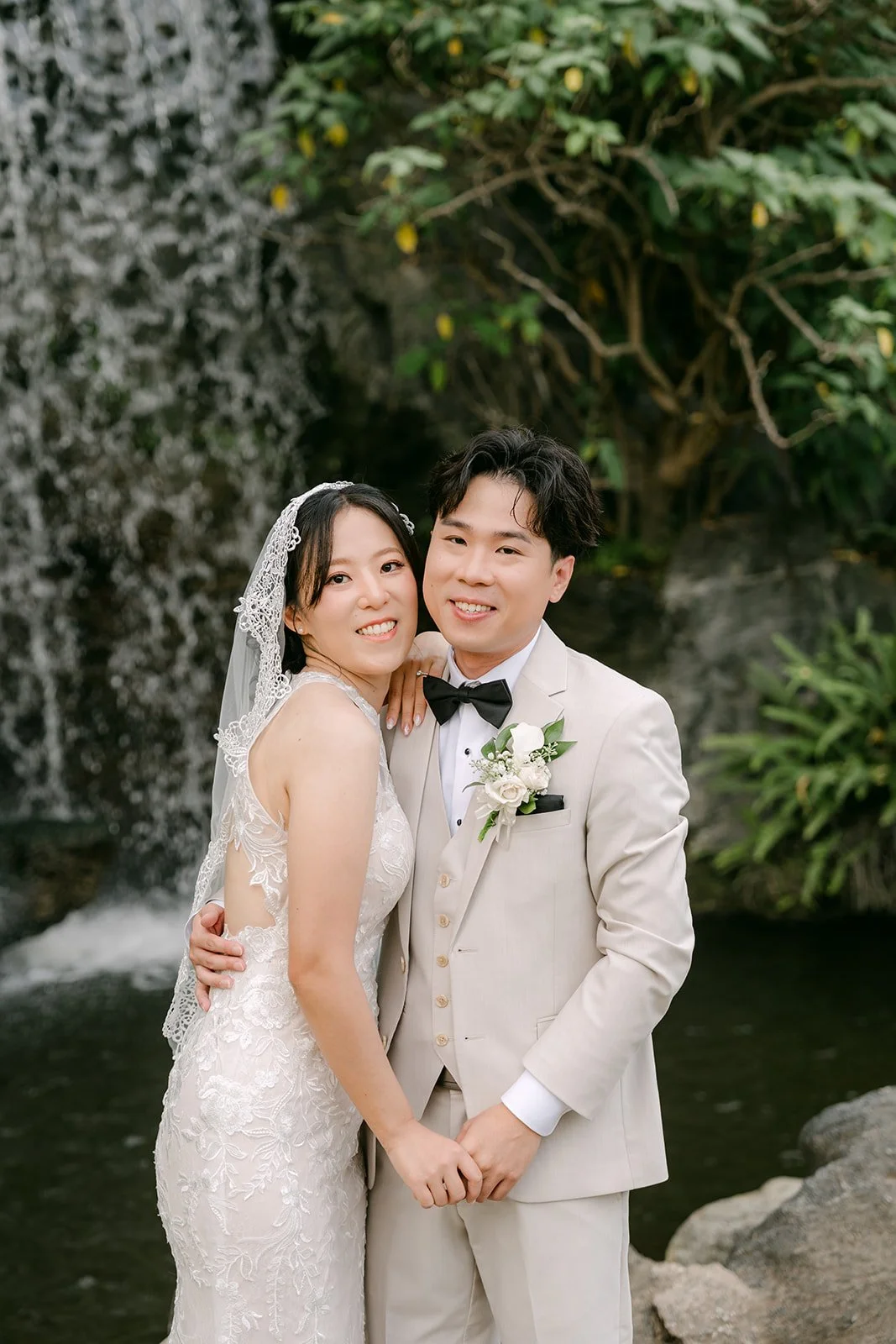 Elaine and Wen smiling in front of the waterfall at the Arboretum.