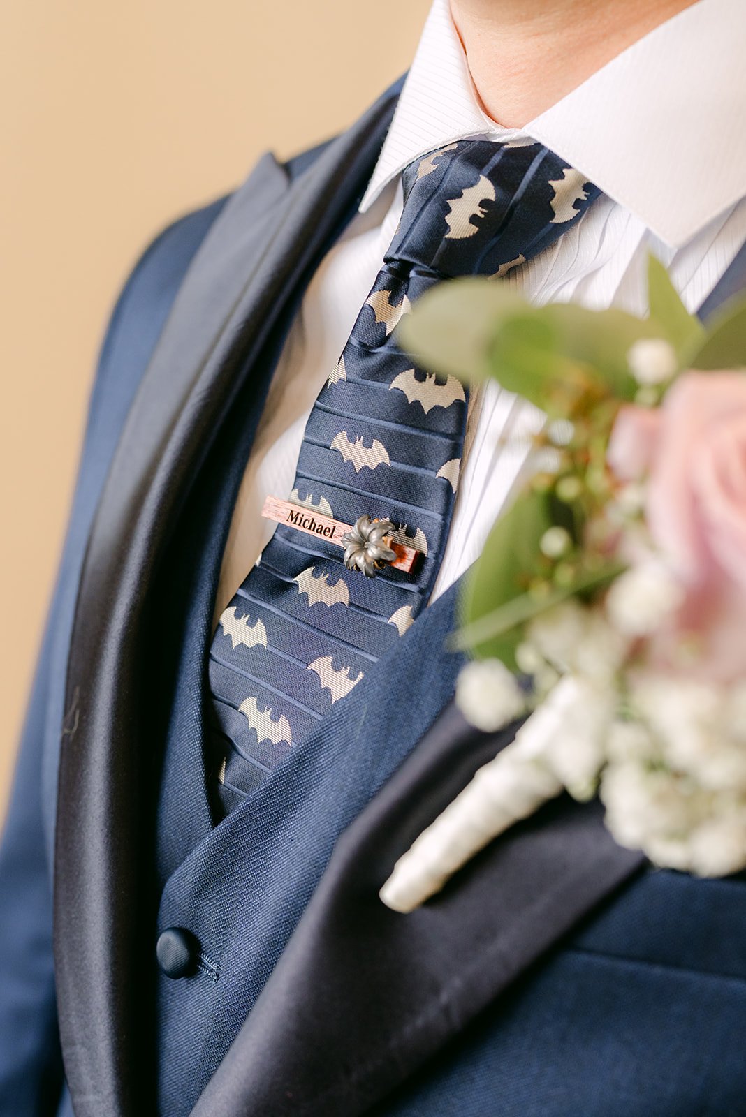 Close detail of Michael's patterned tie and lilac boutonniere.