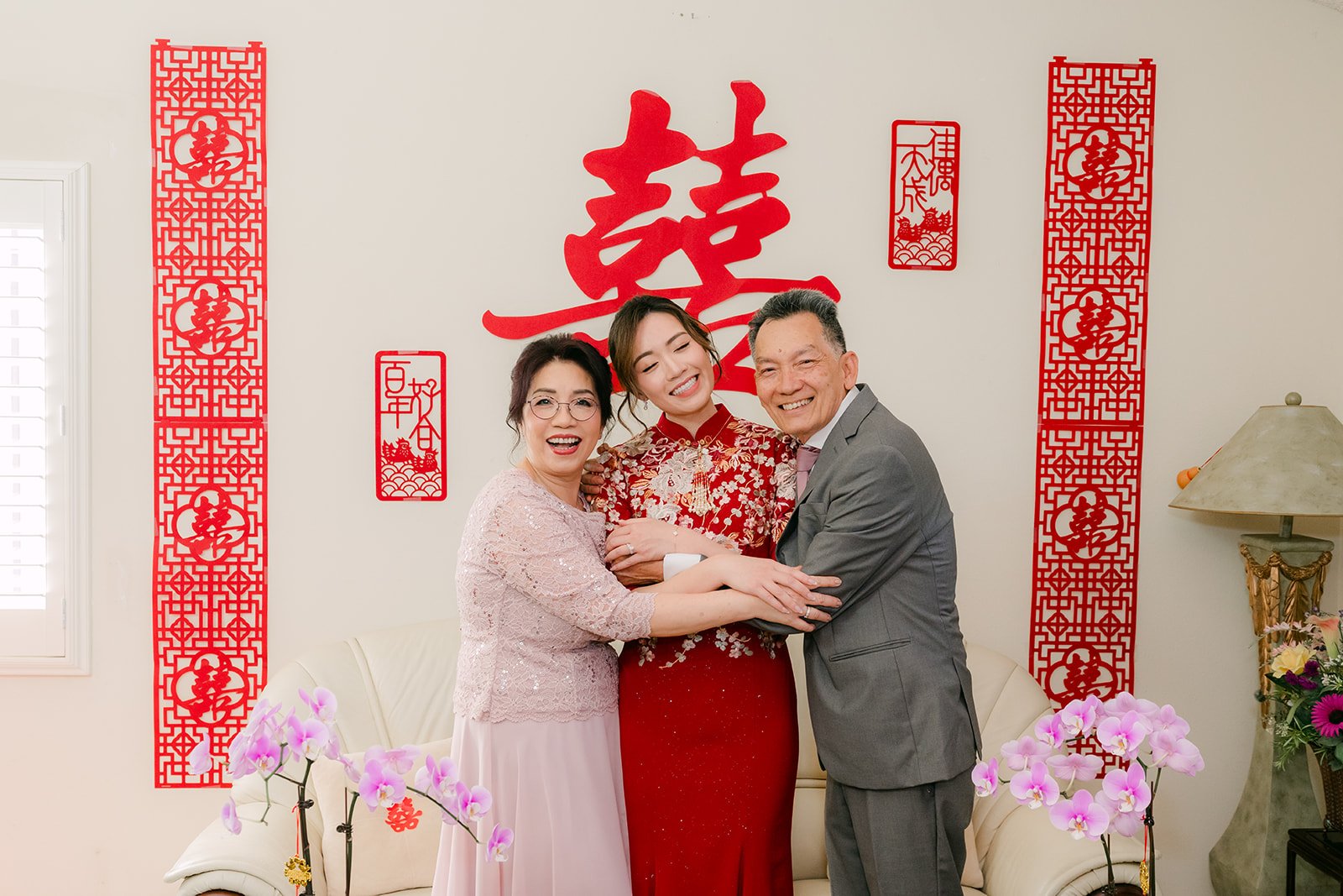 Pauline and Ken with family under the double happiness sign, photographed by One and Only Production.