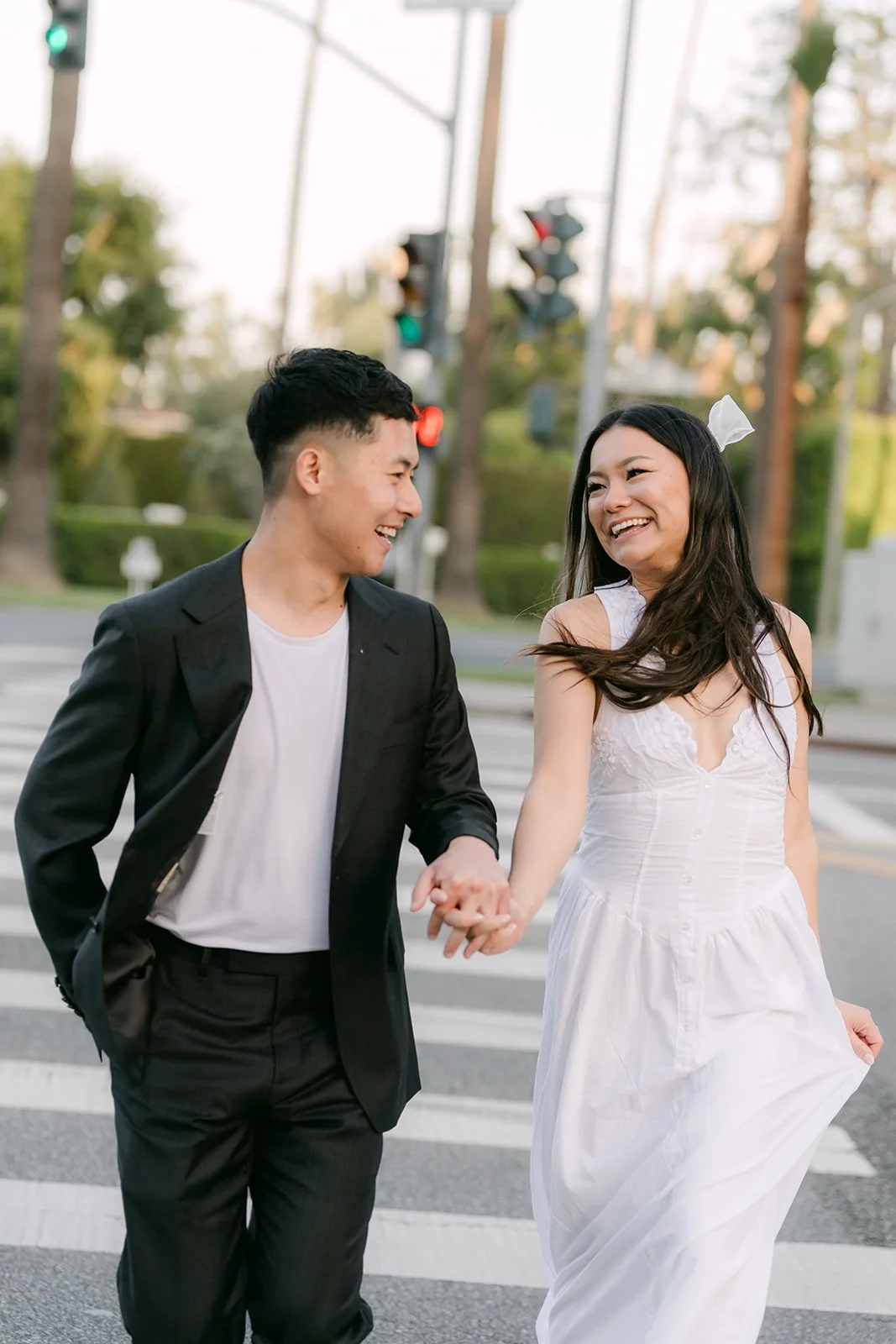 Jadee and Richard hold hands mid-stride in the crosswalk, photographed by One and Only Production.