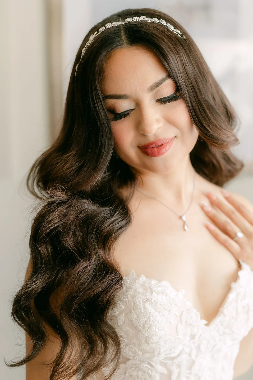 Sandra smiling softly in her tiara and lace gown.