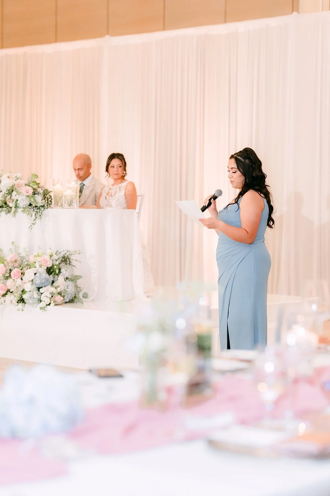 A bridesmaid in light blue gives her speech
