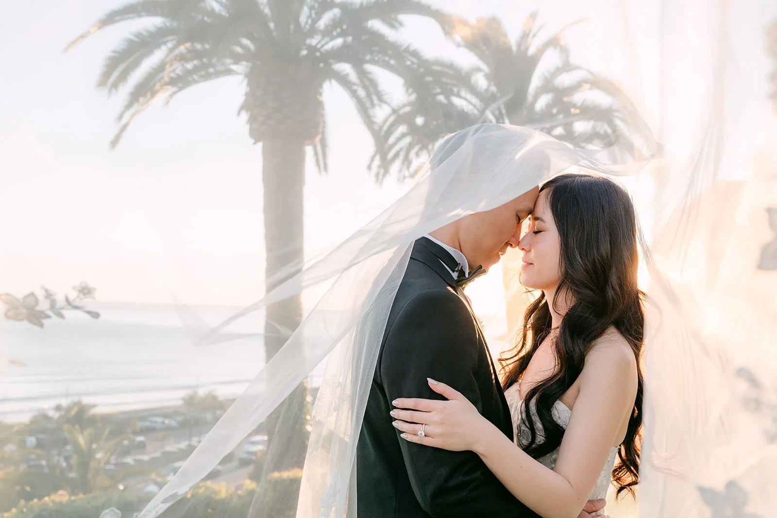 Couple under the veil with the ocean behind them at Bel-Air Bay Club