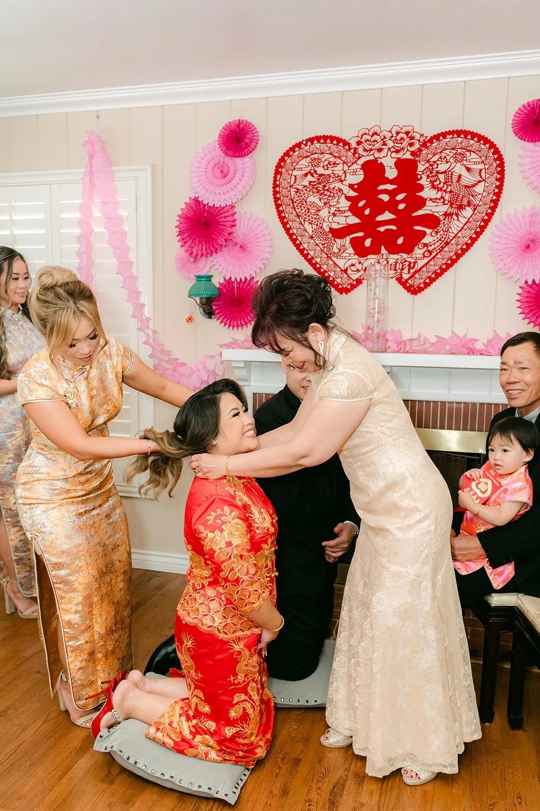Family placing gold jewelry on Candice during the tea ceremony