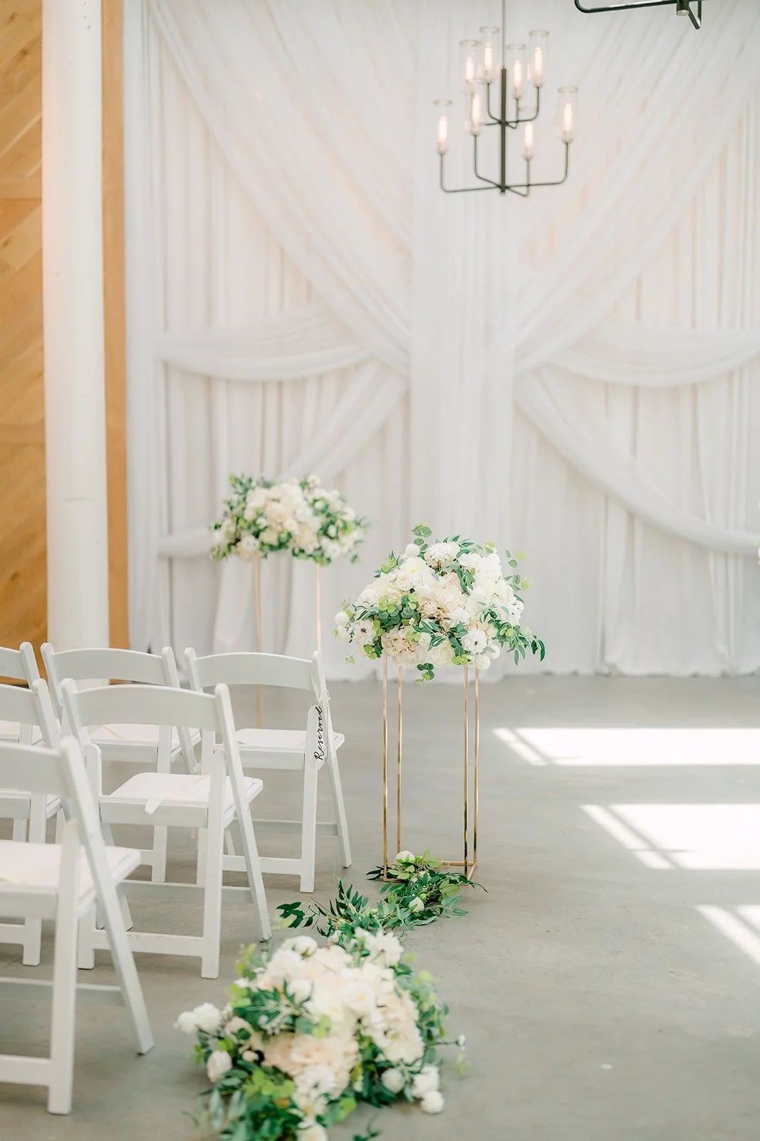 White florals lining the aisle in the chapel