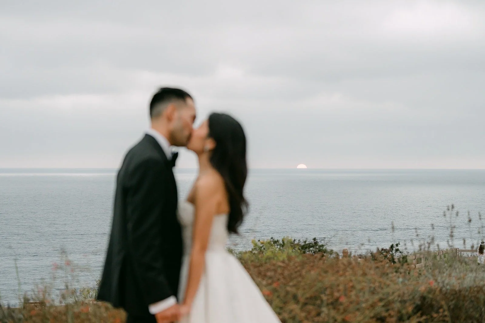 Kim and Vincent silhouetted against the sea