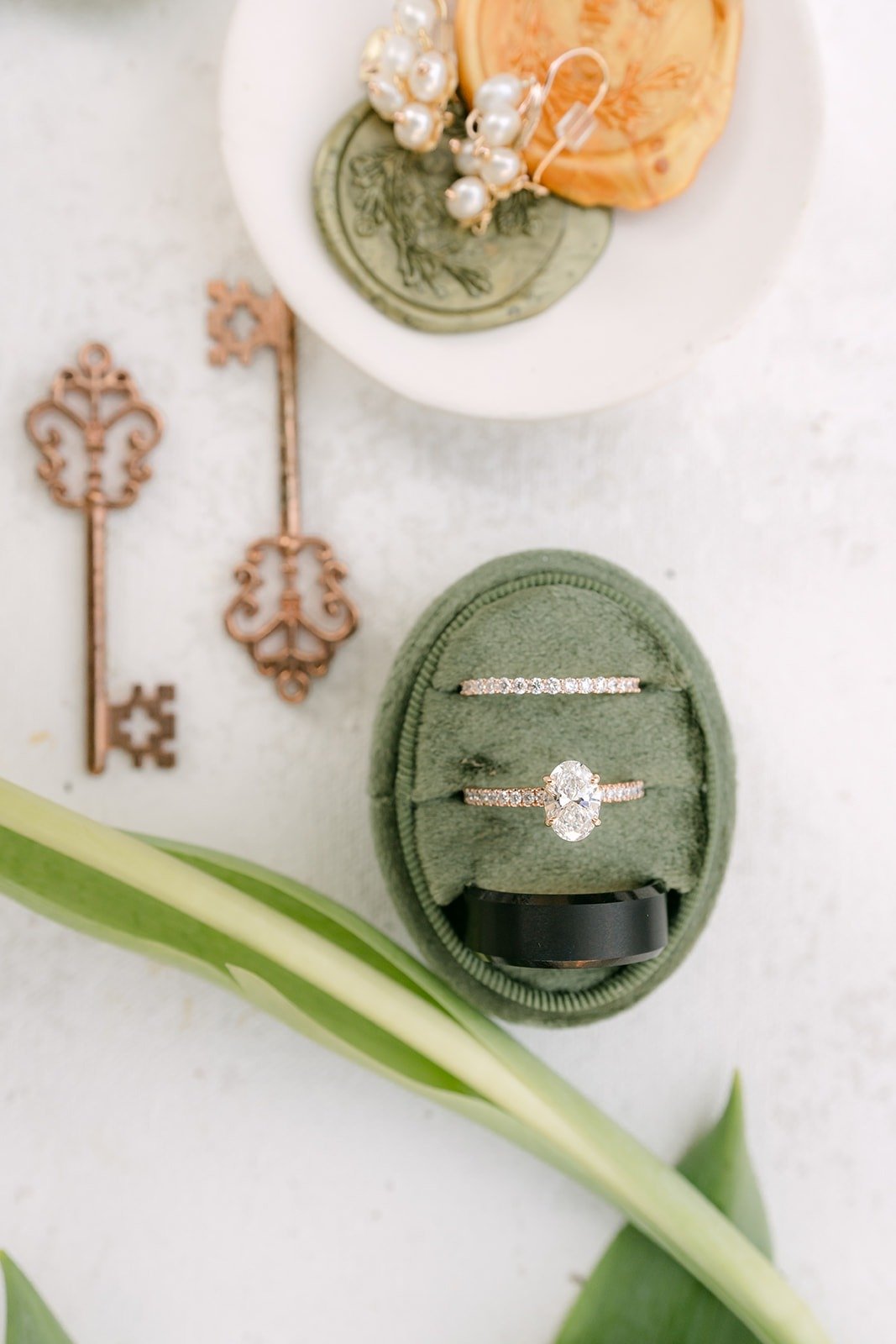 Mariana's engagement ring and wedding bands in a green velvet ring box