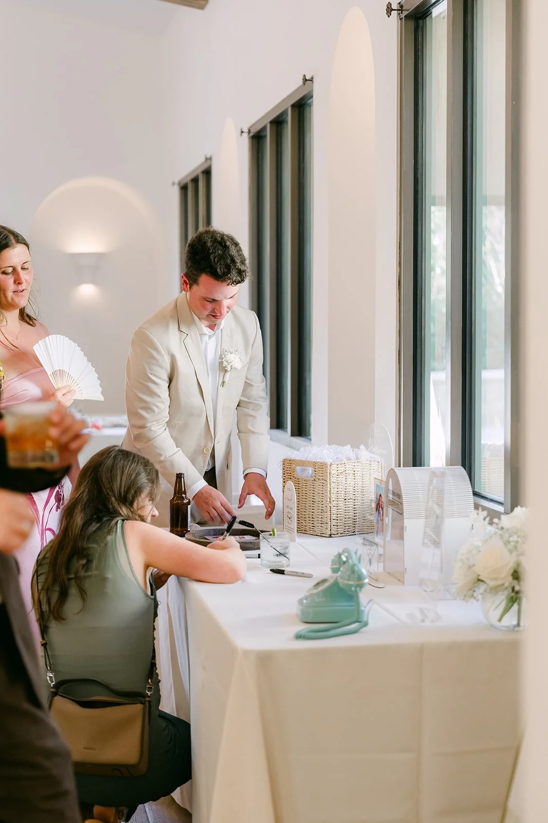 Guest signing the guestbook at a cocktail table
