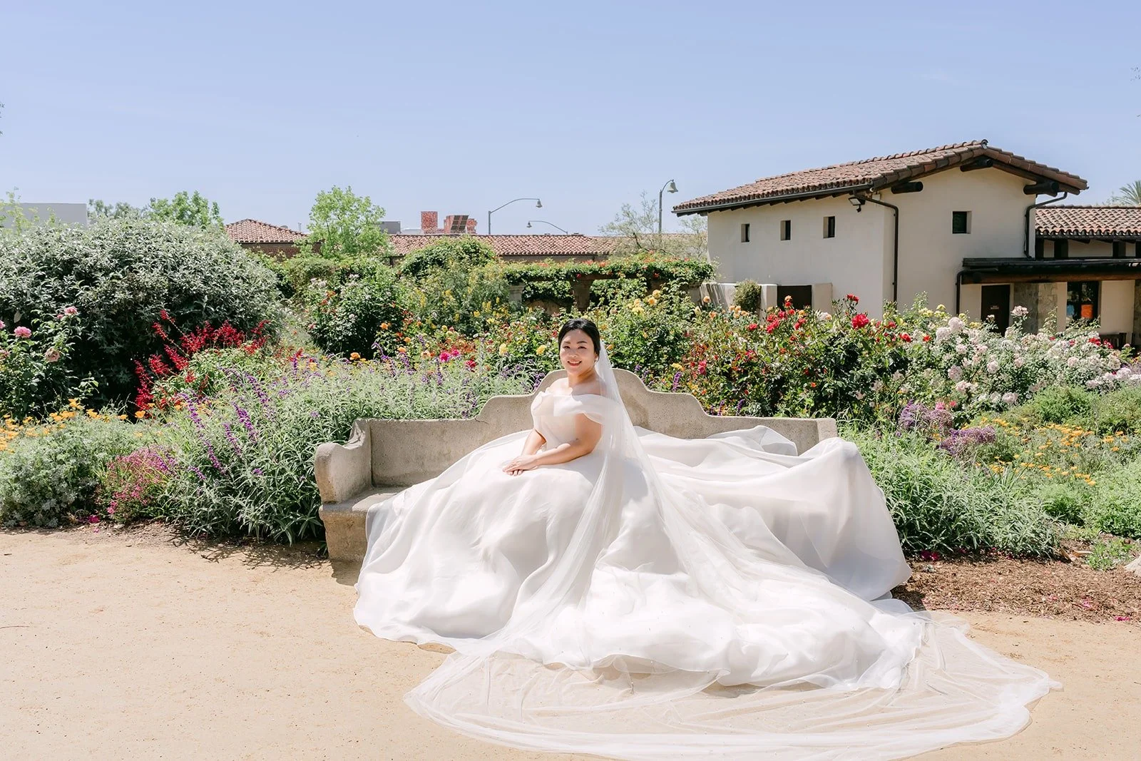 Chorok seated in the gardens at Mission San Juan Capistrano with her gown spread around her