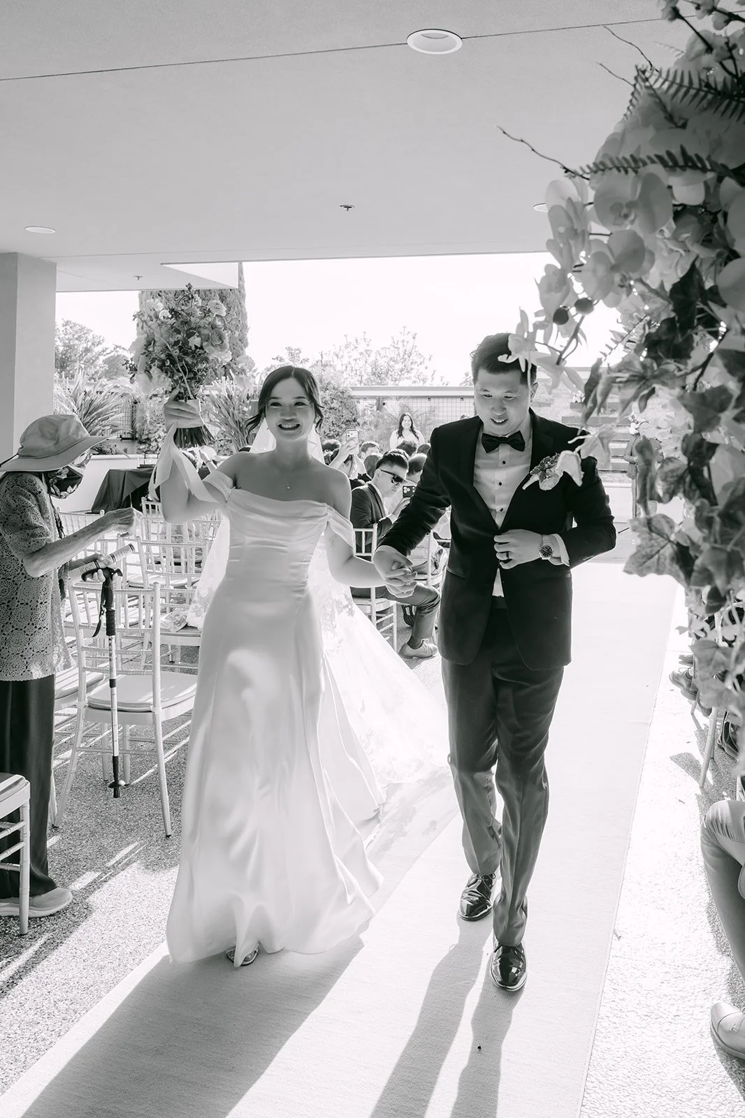 Amanda and San walking back up the aisle as Mr. and Mrs.