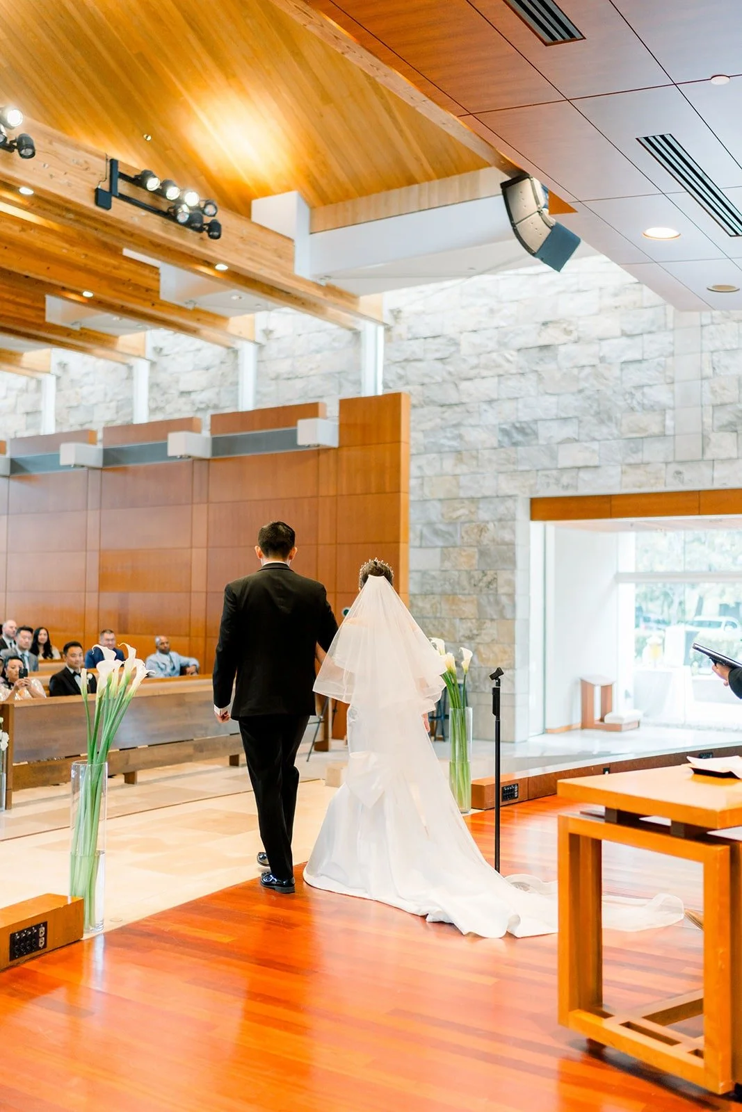 Wide view of the sanctuary under the wood ceiling during the ceremony