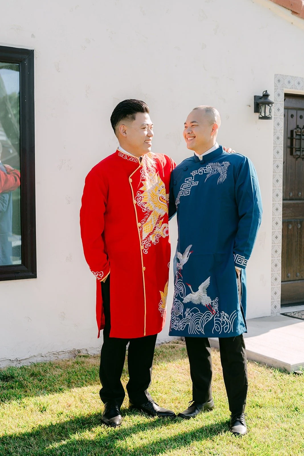 Vincent in red with a groomsman in blue traditional wear