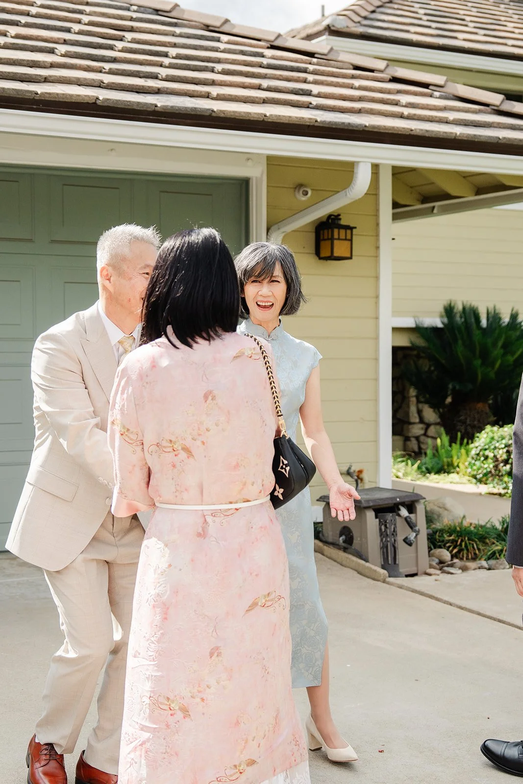 Bridgette's family greeting the groom's side at the door, photographed by One and Only Production.