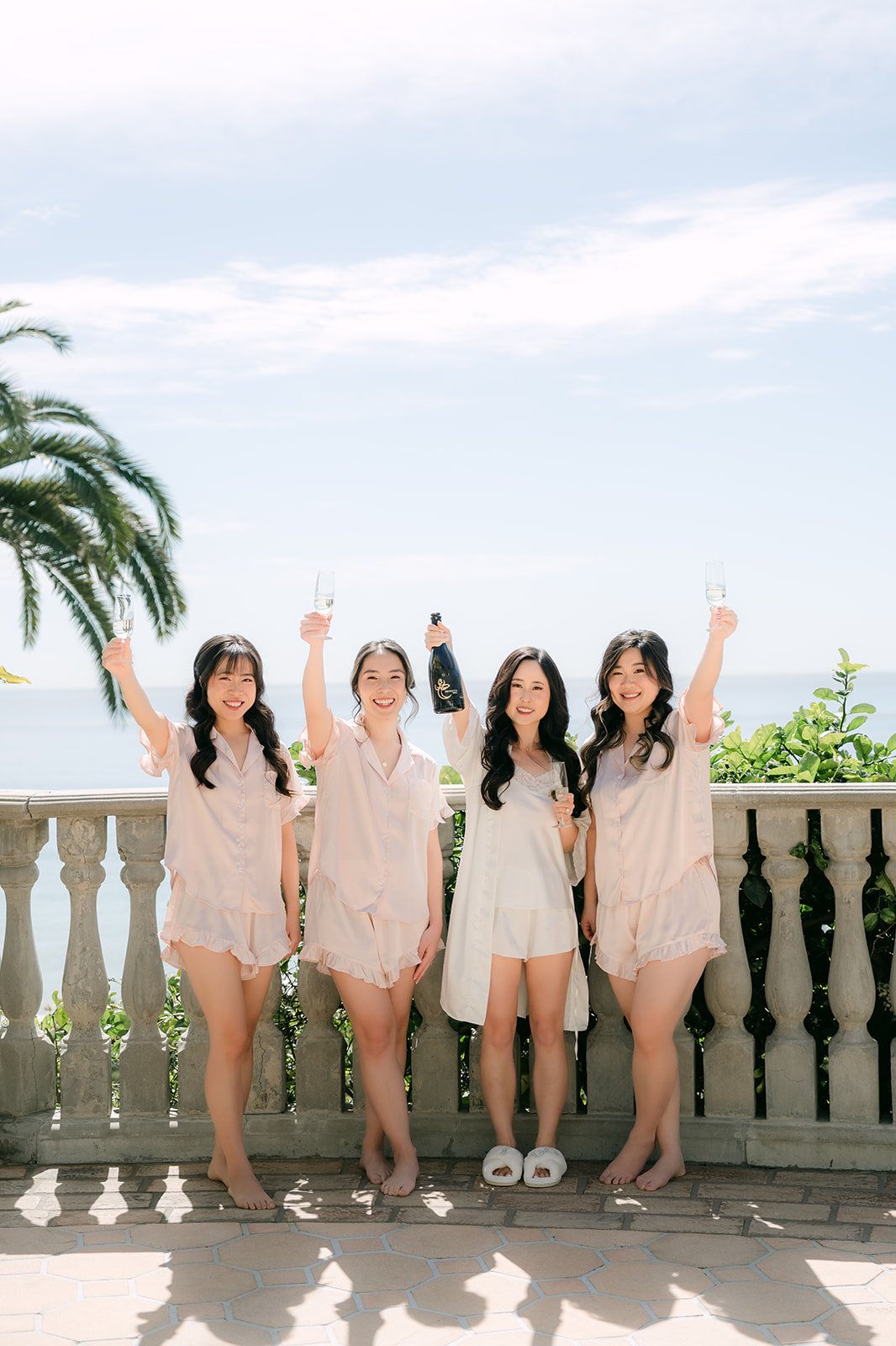 Bridesmaids cheering with champagne on the ocean terrace