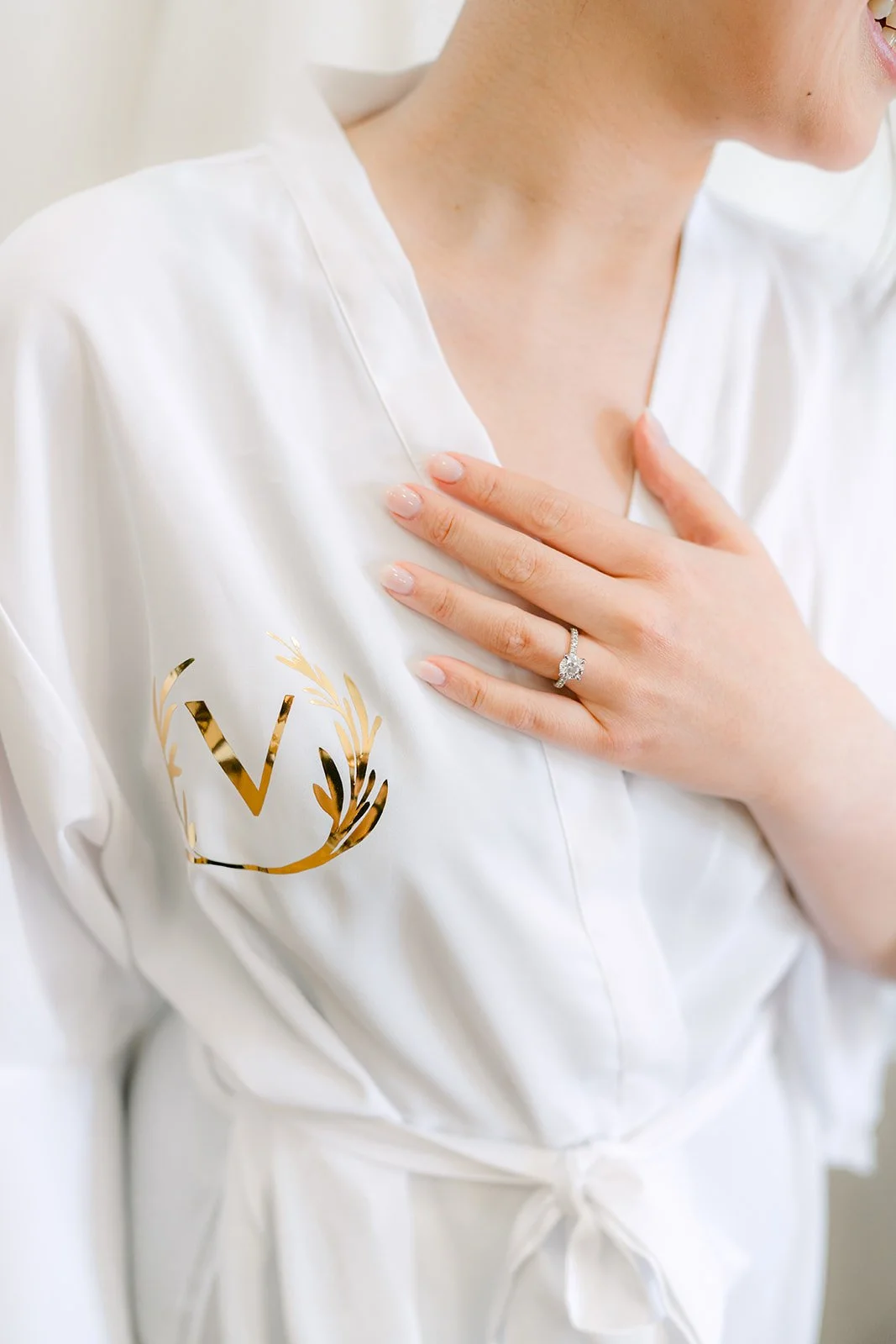 Close-up of the bride's engagement ring and monogrammed satin robe