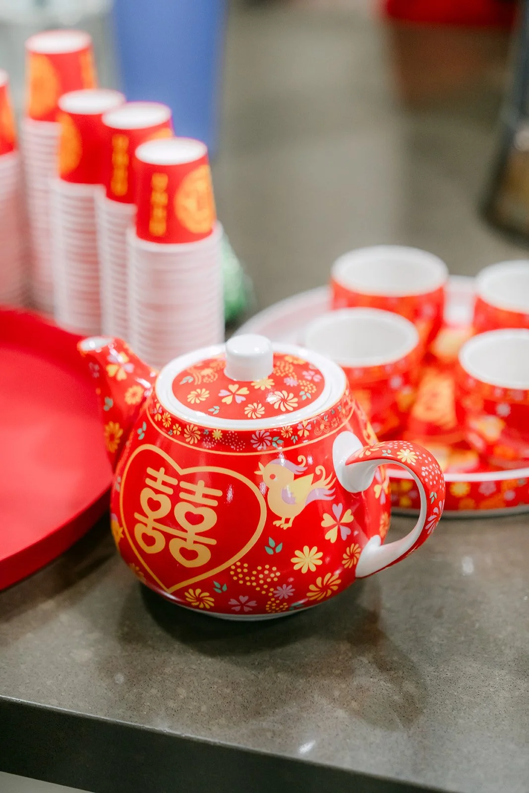 A red double happiness teapot and stacked cups ready for the tea ceremony.