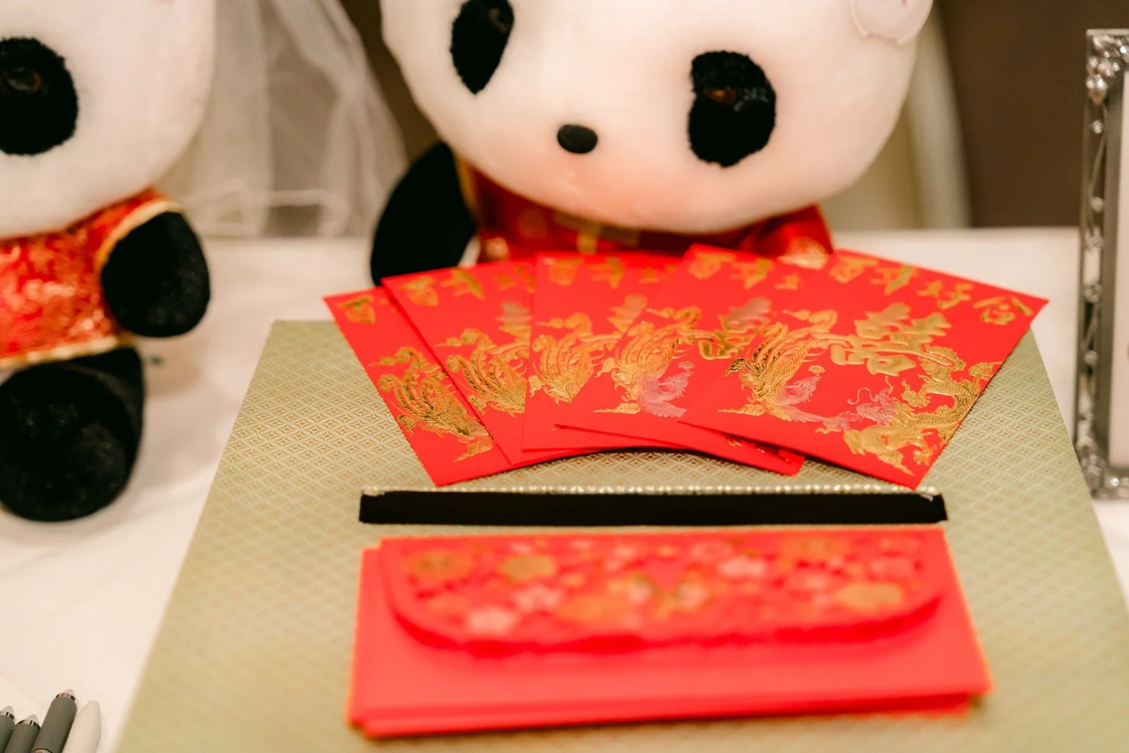 A panda plush in red guarding the red envelope box on the welcome table