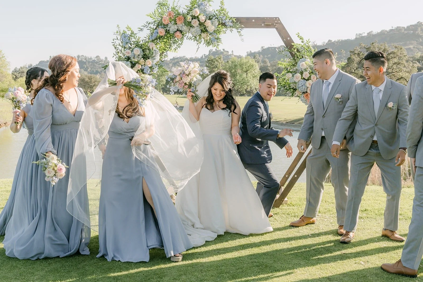 The wedding party laughing around Florence and Jordan, photographed by One and Only Production