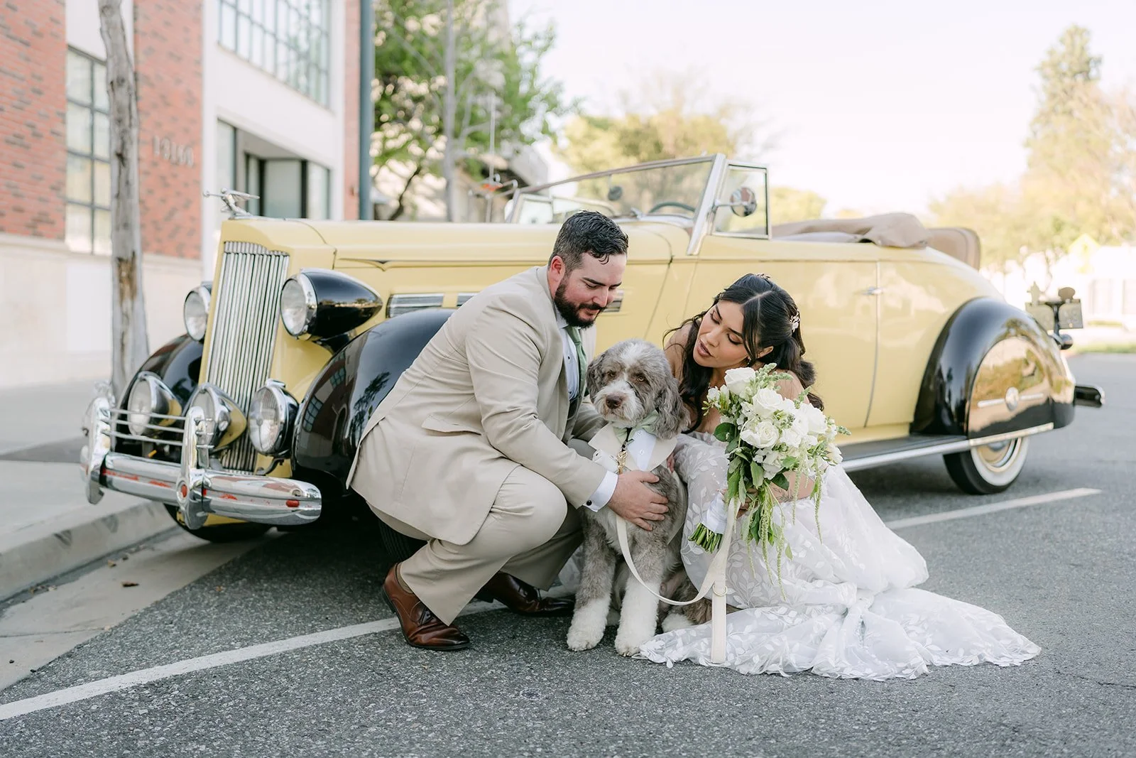 Fernanda and Cody with Olive in front of the vintage car.
