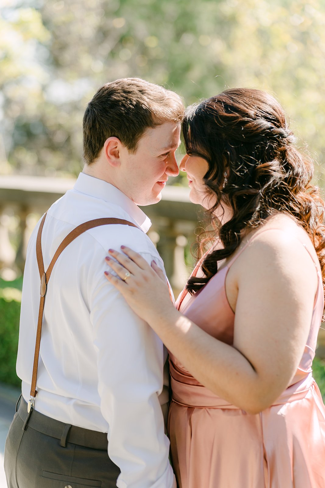 Saira and Matthew in a warm embrace in soft afternoon sunlight.