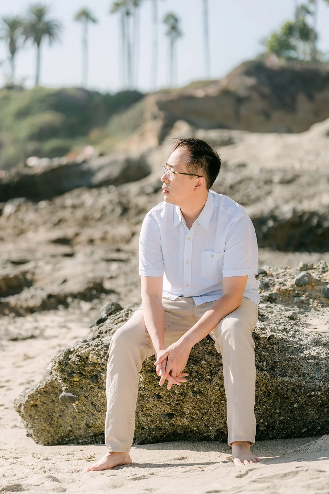 Lawrence sitting on a rock on the beach.
