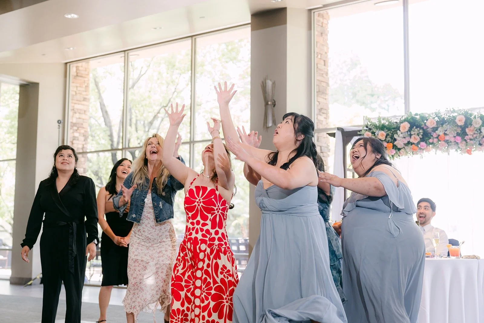 Guests reaching for the bouquet in midair