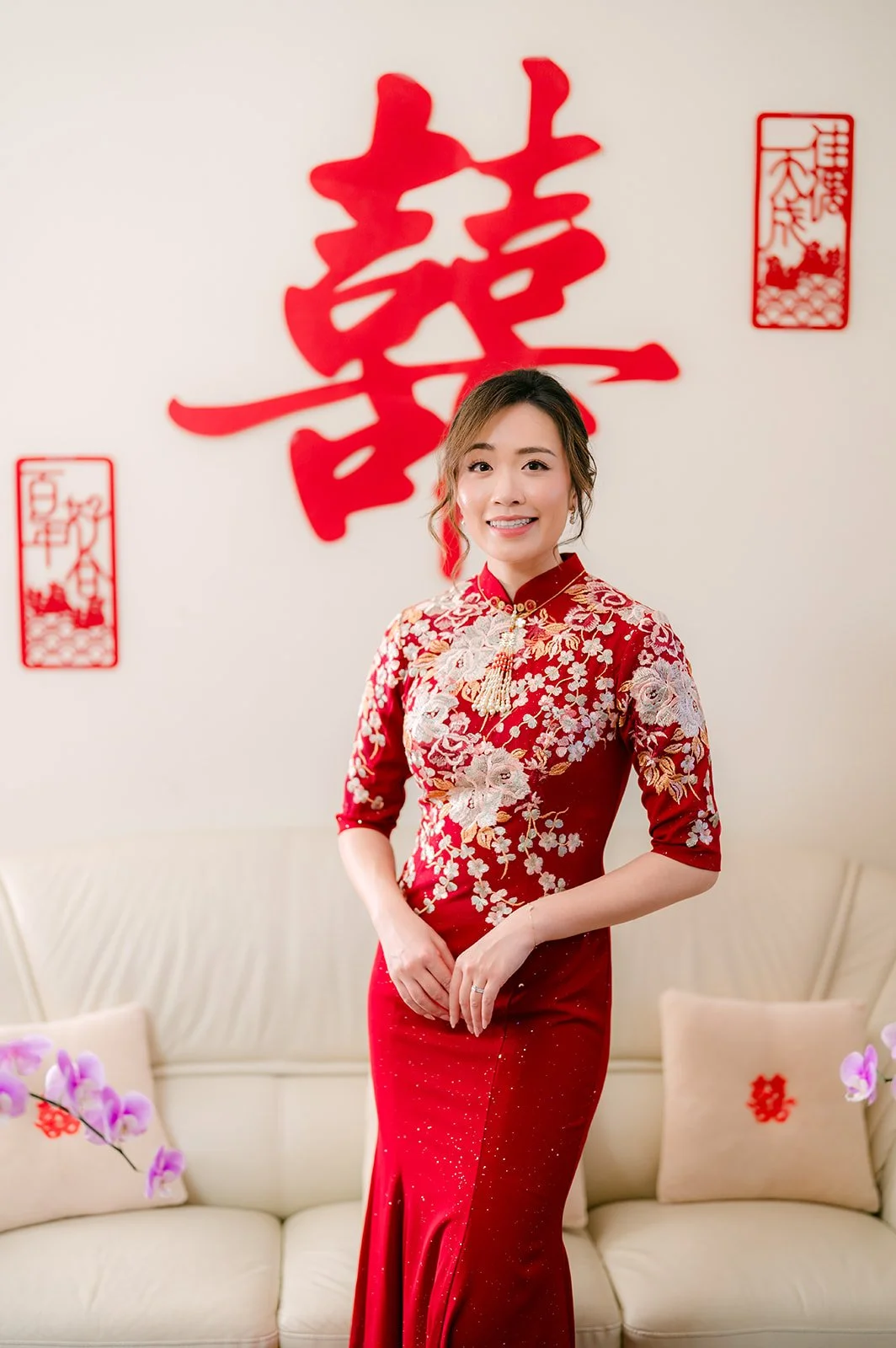 Pauline standing in the living room in her qipao.