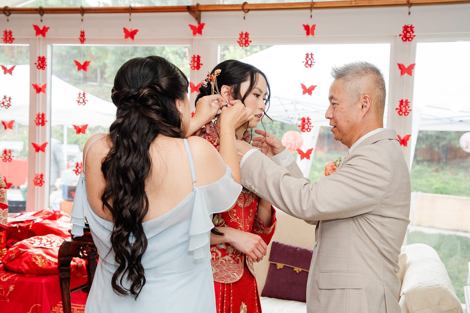 A relative fastening a necklace on Bridgette during the tea ceremony.