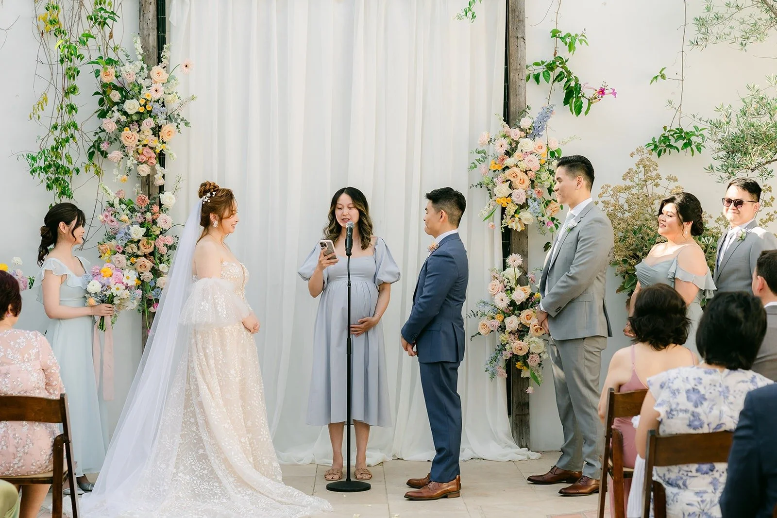 Wide view of the courtyard ceremony with pastel florals on both sides