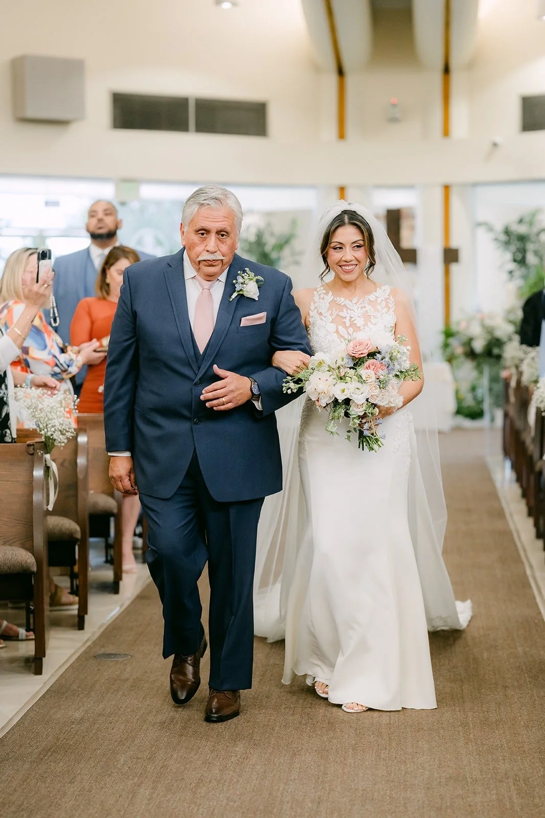 Francesca walks down the aisle with a family member