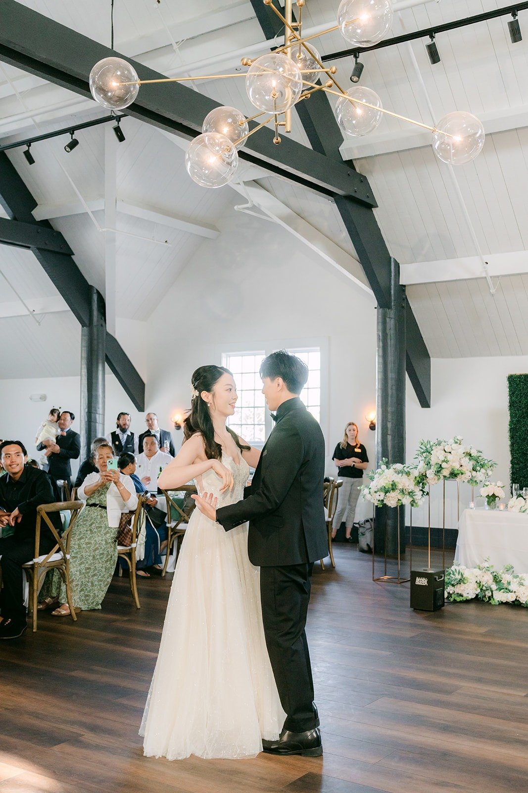 Tin and Fong dancing under the chandeliers