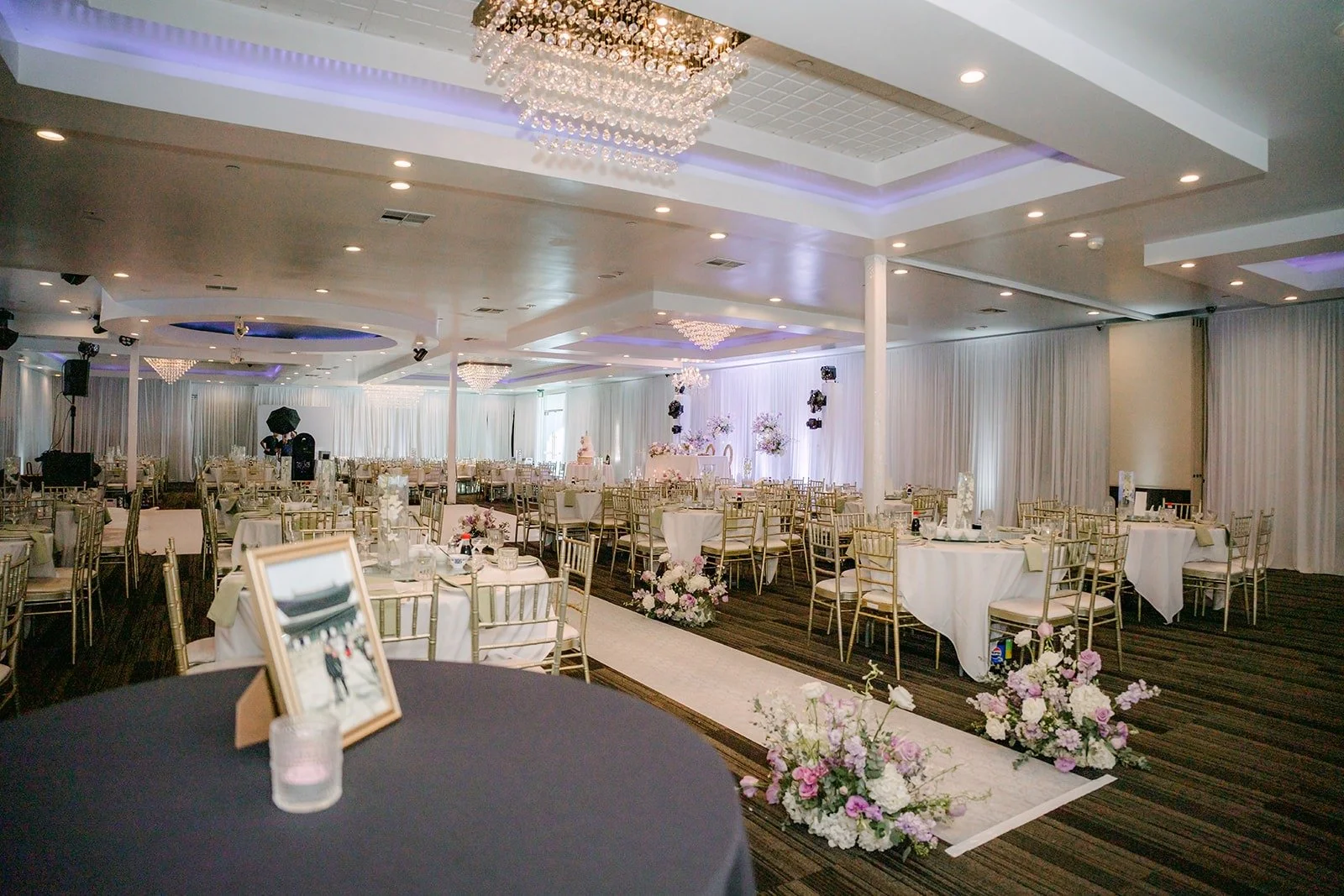 The dining room at Diamond Seafood Palace 3 set with round tables, white linens and a chandelier