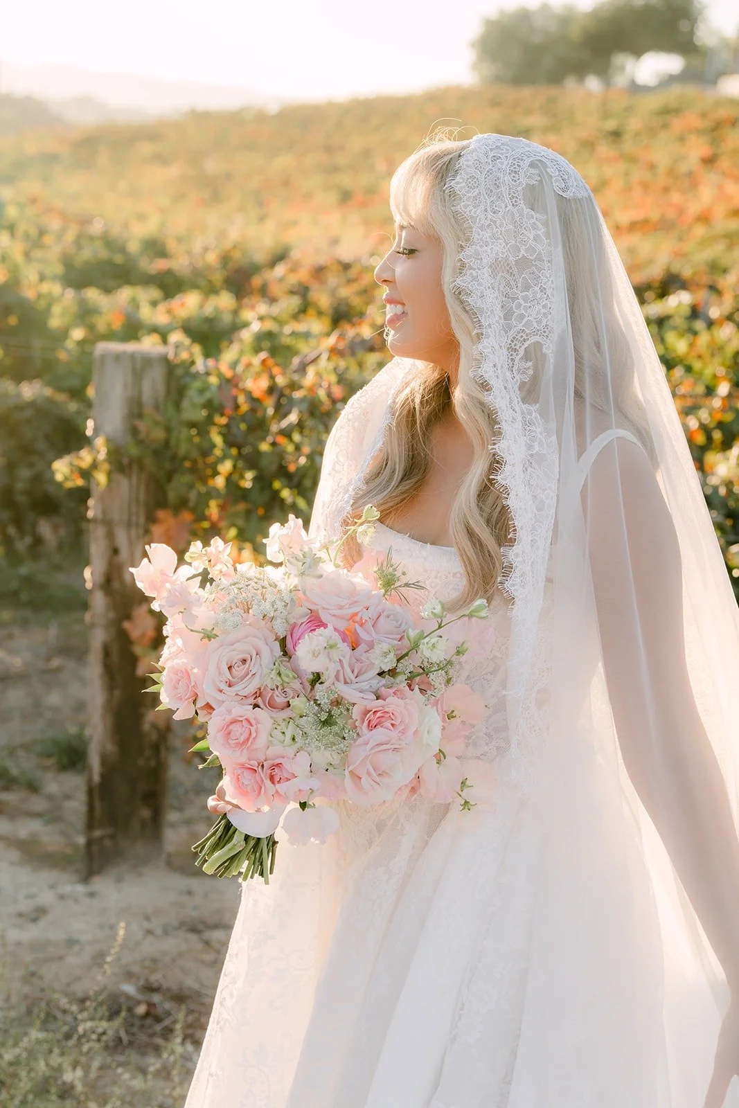Konitha and her bouquet beside the vineyard rows, photographed by One and Only Production