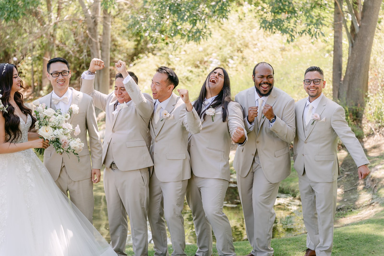 Groomsmen in champagne suits celebrating with Sandra and Kevin.