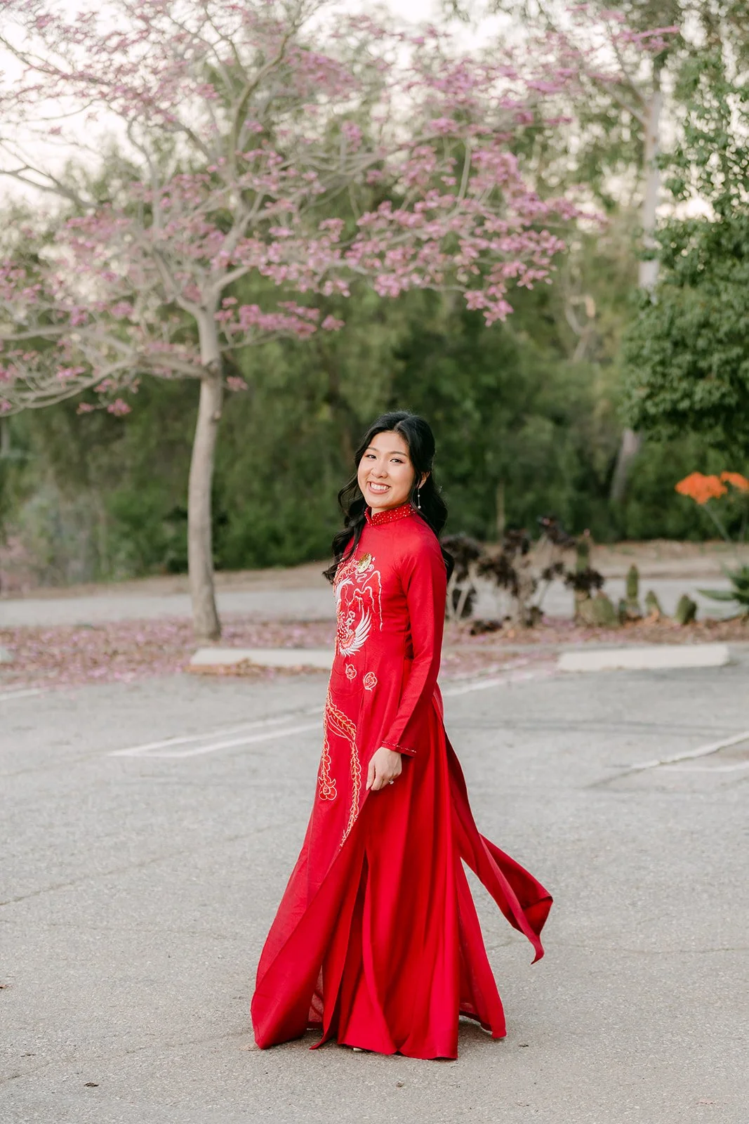 Kim twirling in her red ao dai on the garden path.