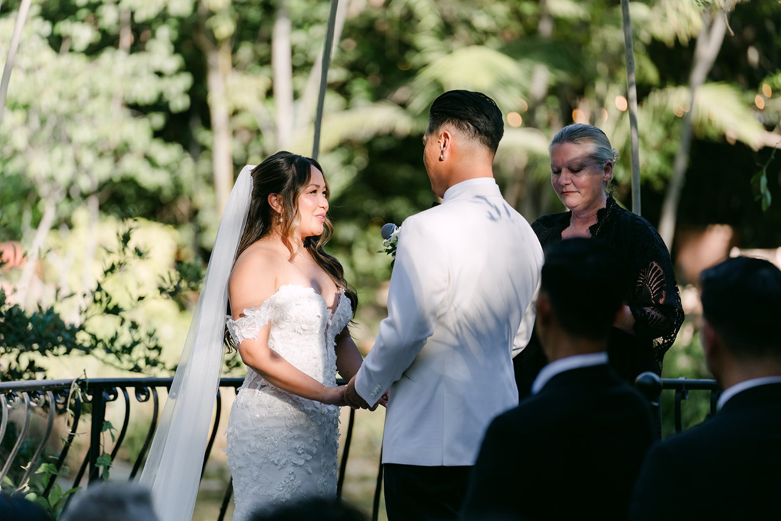 Nicole and Caryl facing each other during their ceremony at Eden Gardens.