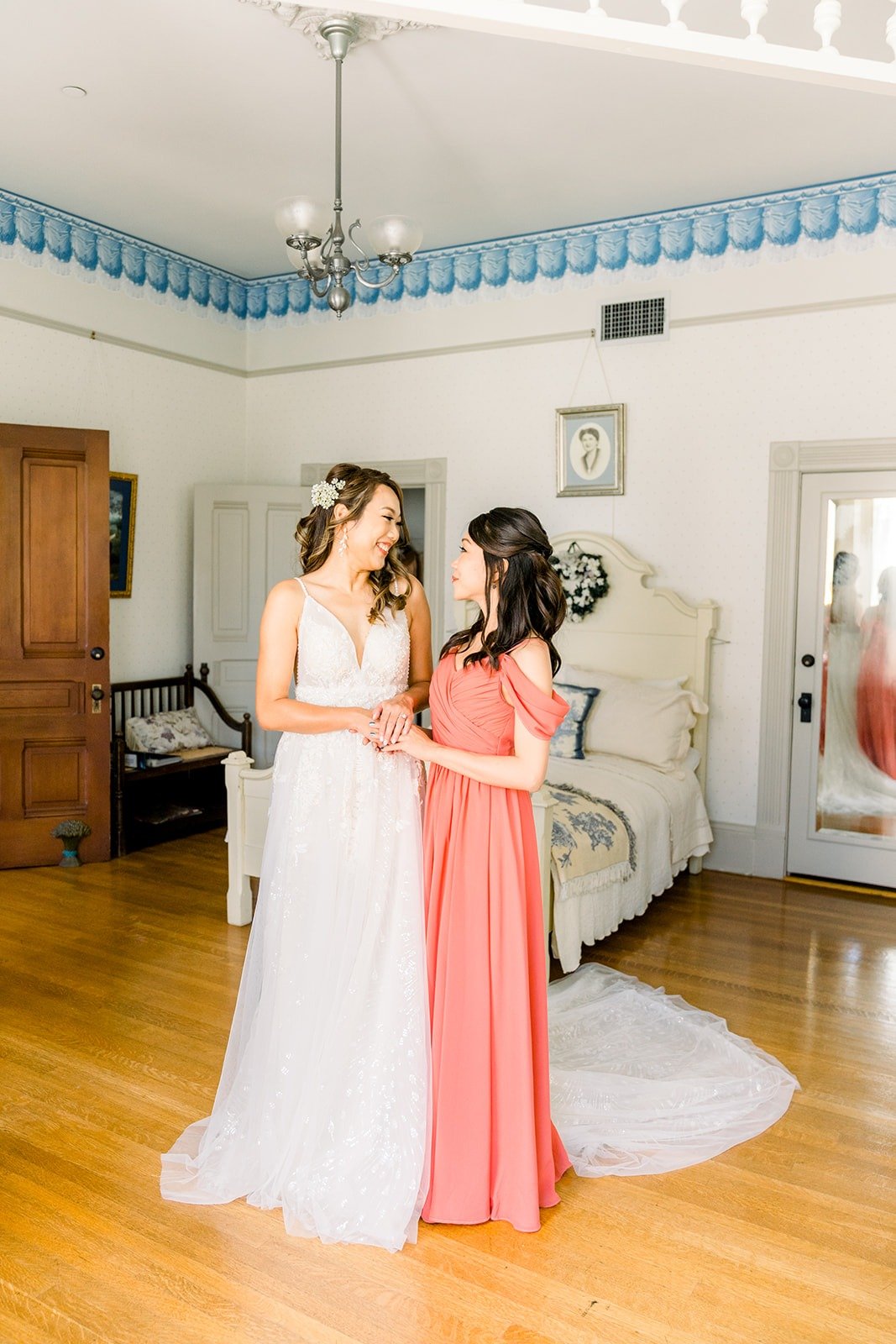 Ariel and a bridesmaid in coral sharing a laugh