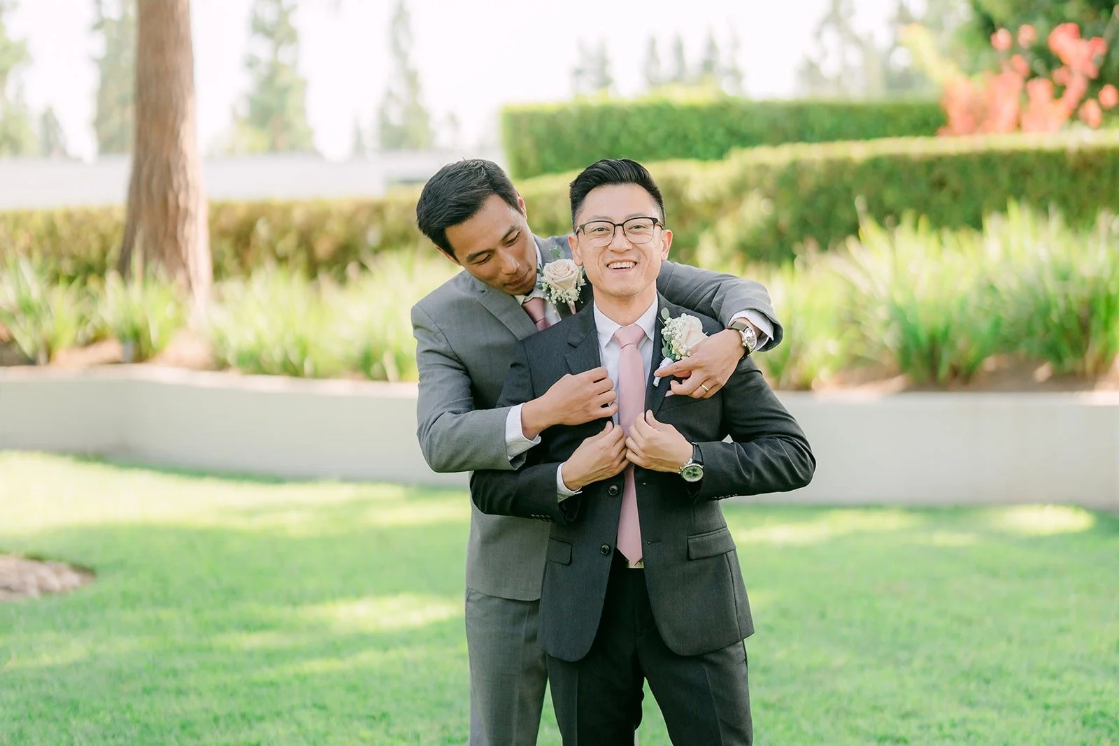 Alex and a groomsman laughing on the lawn