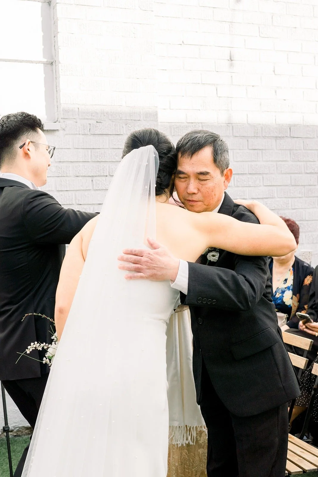 Cindy embraces a family member at the end of the aisle