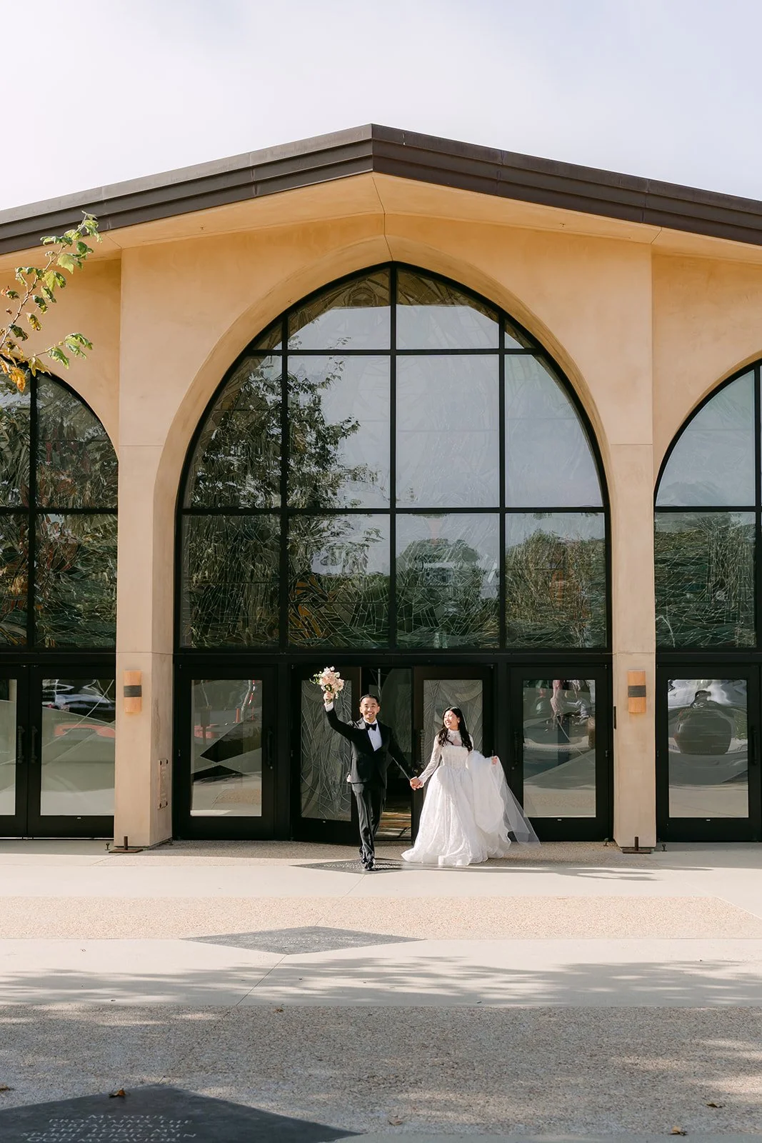 Kim and Vincent in front of the arched windows of St. John Fisher Church