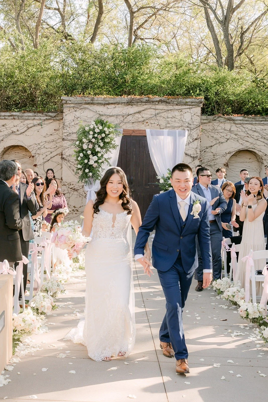 Kelli and Alex walking back up the aisle as newlyweds, all smiles