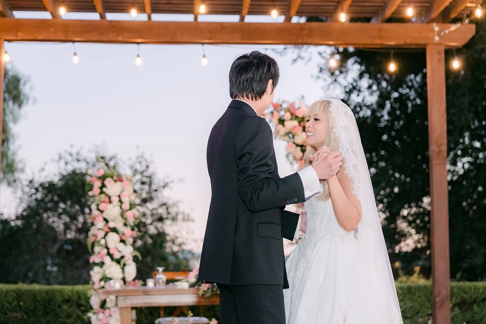 Konitha and Job dancing under the string lit pergola