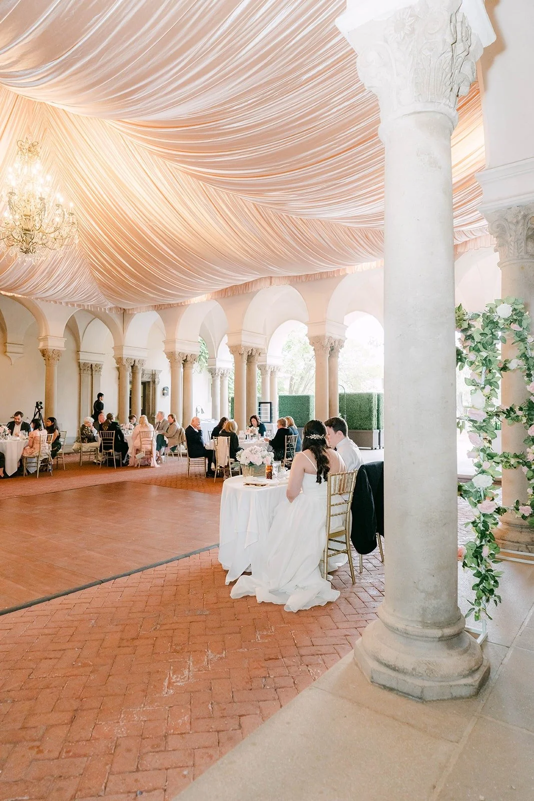 The reception filling up beneath the draped ceiling