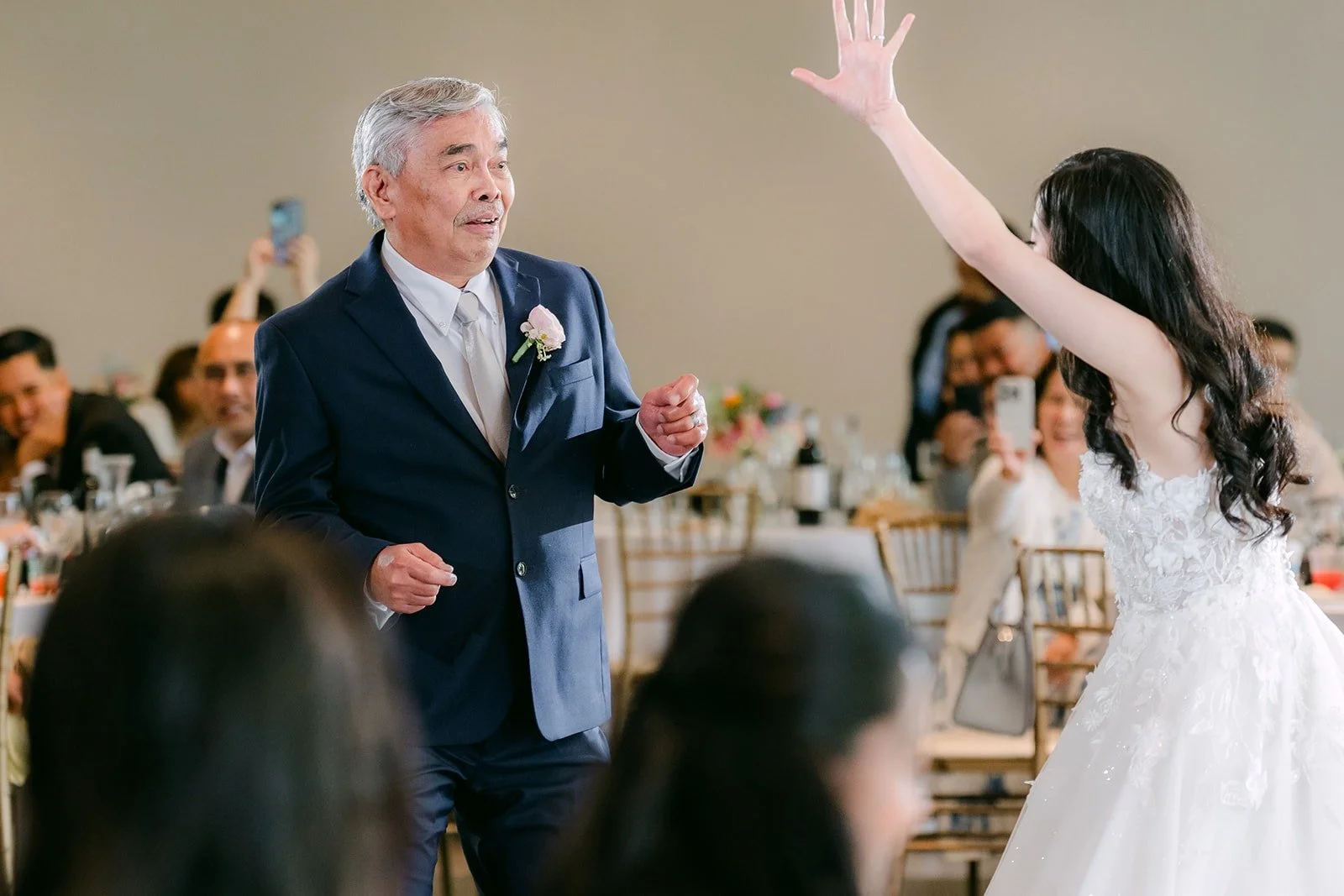 Natalie dancing with her dad, arms in the air to Twist and Shout