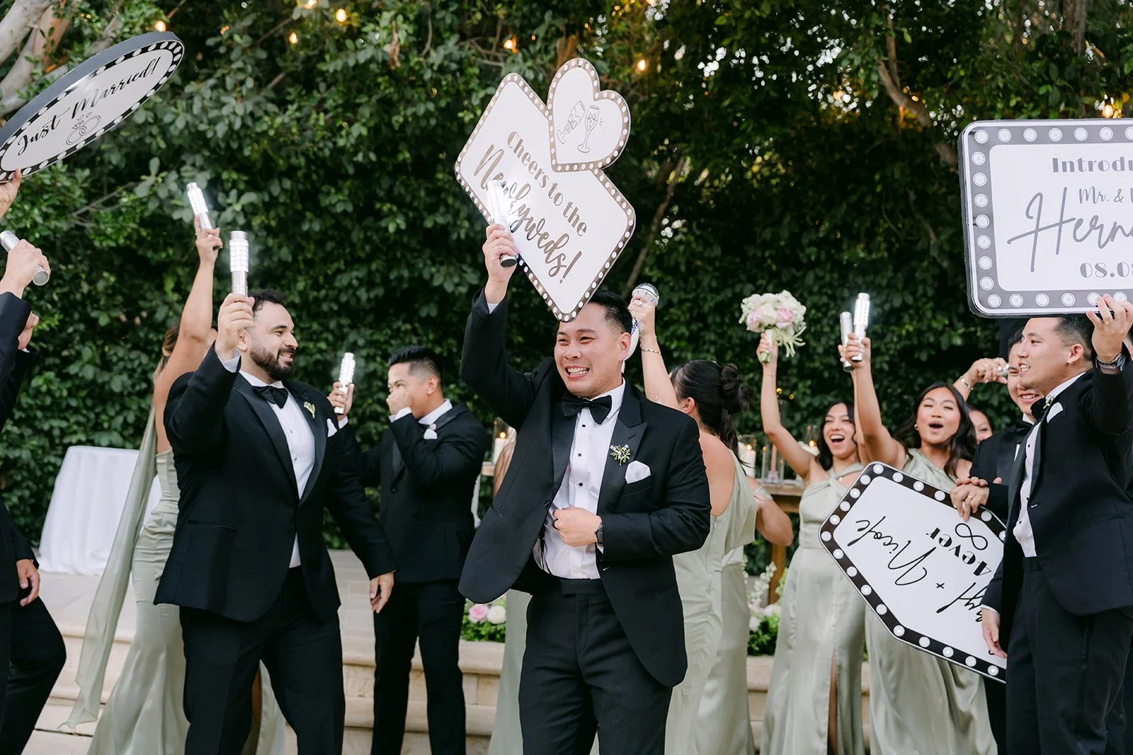 The wedding party waving signs and napkins during their grand entrance.