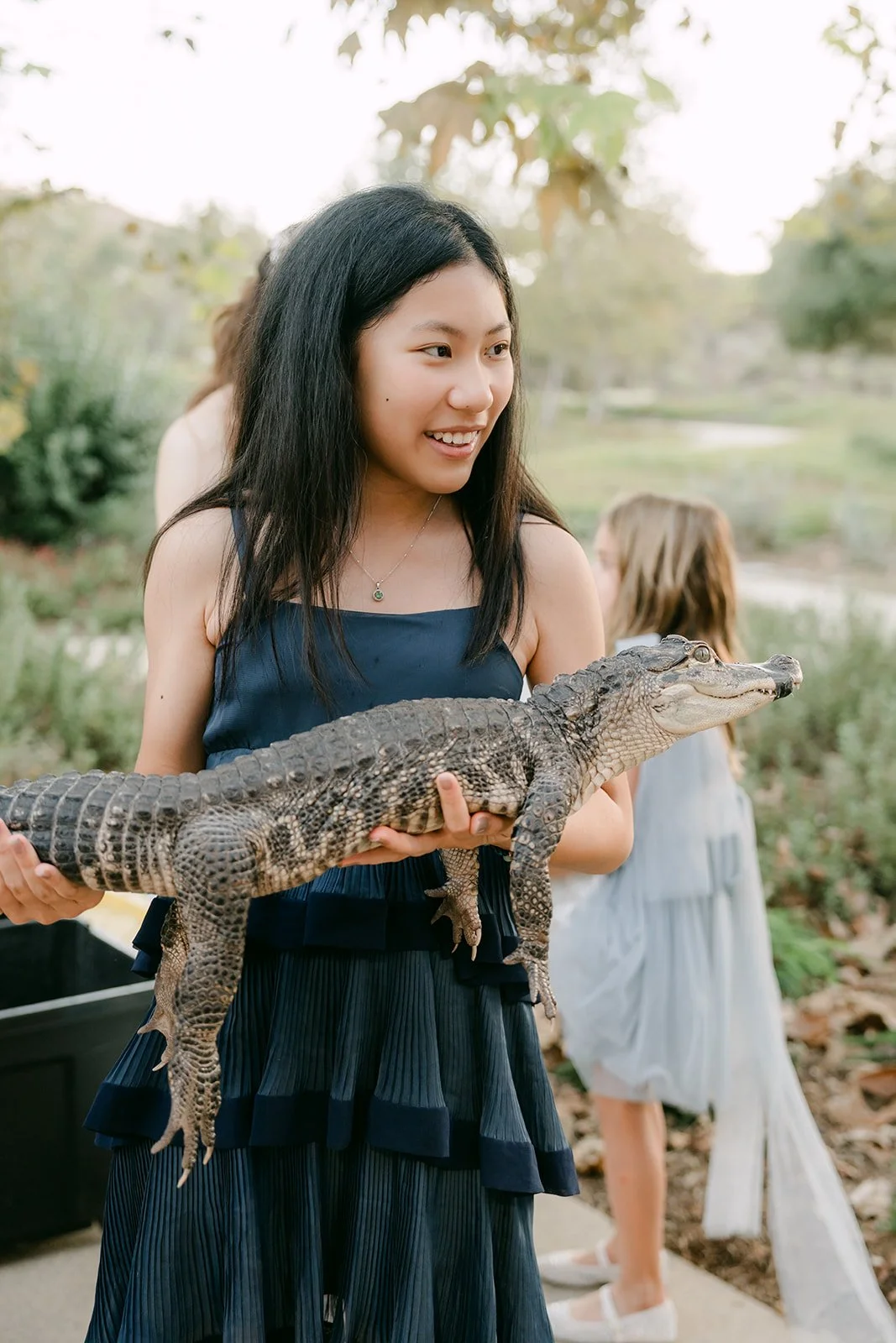 A guest holding the mini alligator with a big smile.